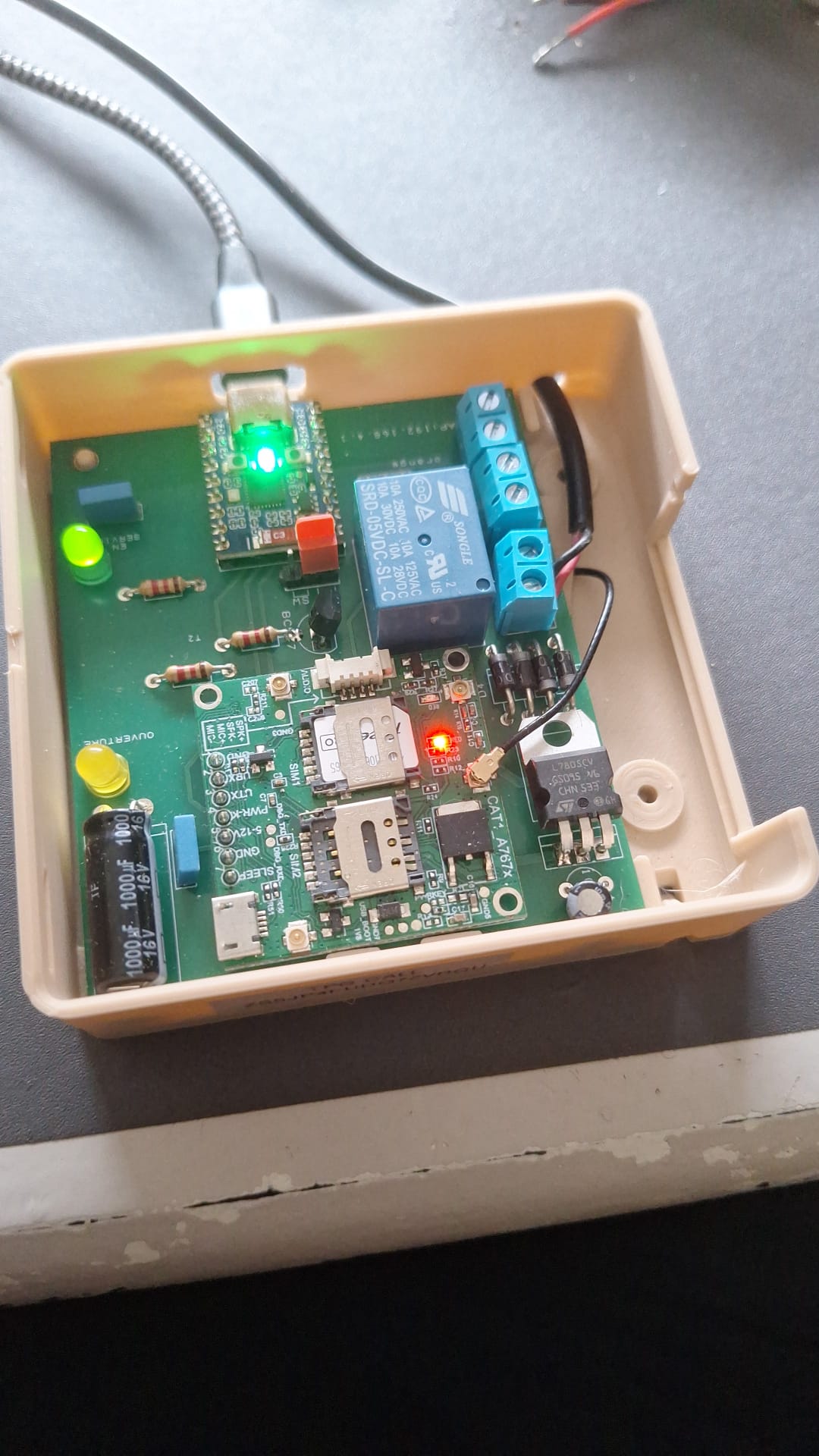 TPG CALL ouvert : carte ESP32, modem mobile, relais et deux voyants dans leur boîtier
